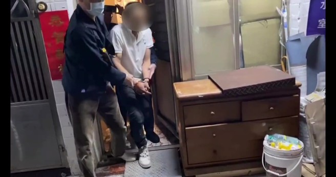 員警來到基河路一處民宅查證時，發現涉嫌竊盜的廖姓男子竟躲藏在床鋪下方，試圖矇混過關，但仍被警方當場識破，壓制逮捕。（圖／簡銘柱翻攝）