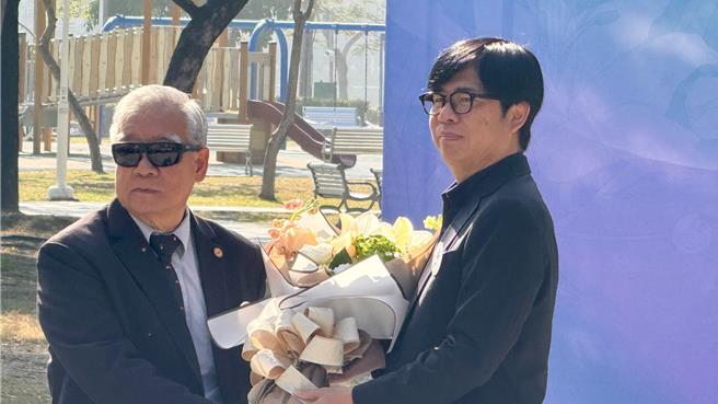 高雄市长陈其迈代表向高雄市二二八关怀协会理事长王文宏献花。（柯宗纬摄）