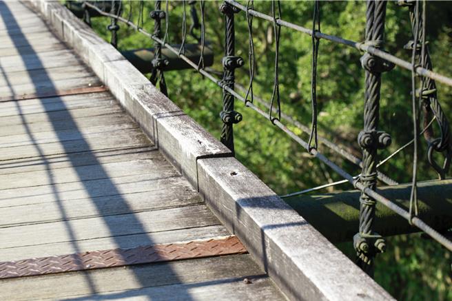 苗栗头屋乡海棠岛的永春宫吊桥，歷经50年未大规模维修，桥体木板腐朽、钢索疲劳，安全疑虑日增。（吕丽甄摄）