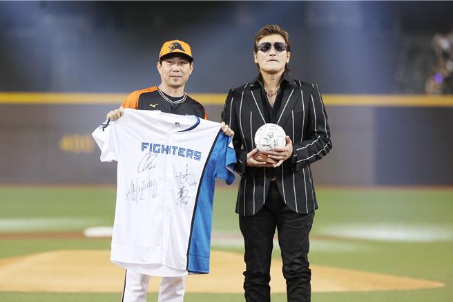 统一狮总教练林岳平（左起）与火腿监督新庄刚志赛前交换纪念品。（杜宜谙摄）