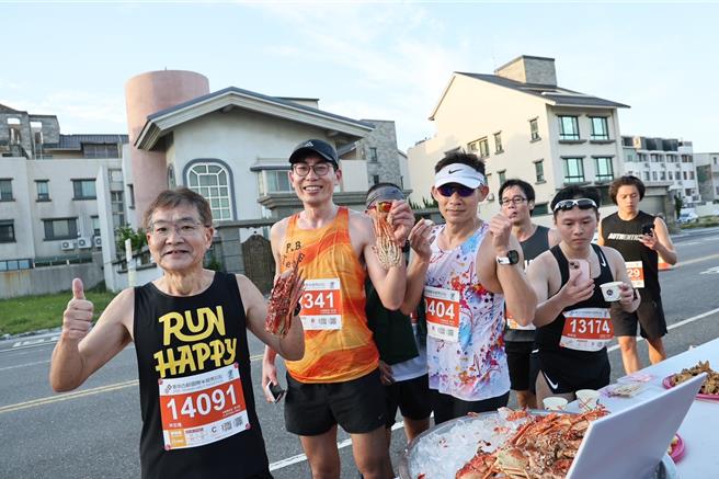2025台南古都國際半程馬拉松2日清晨開跑，跑友開心跟與龍蝦補給品合影。（台南市政府提供／曹婷婷台南傳真）