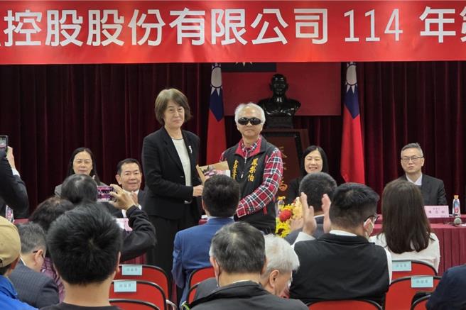 永丰金今日召开股东临时会，小股东凤梨伯送上花束感谢董事长陈思宽（左）。（黄琮渊摄）