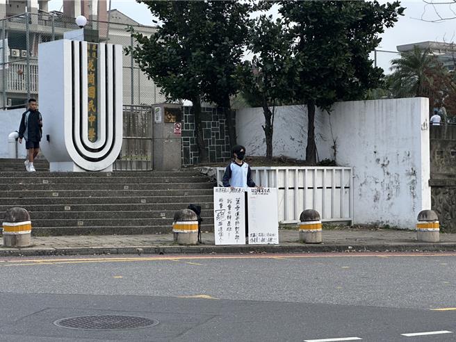 花莲花岗国中有名男校友，今天傍晚穿着校服，站在校门口声援叶春莲。（罗亦晽摄）