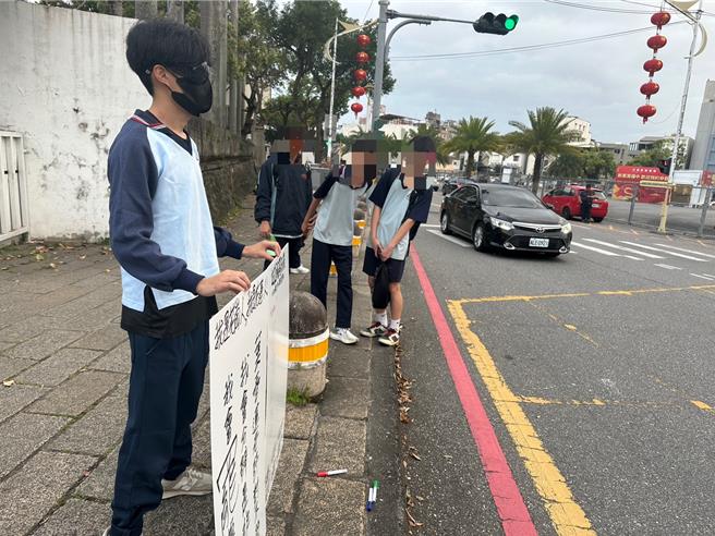 花莲花岗国中有名男校友，今天傍晚穿着校服，站在校门口声援叶春莲，引起在校生关注。（罗亦晽摄）