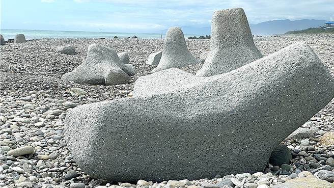 「超好躺的消波块」与一般直立摆放的消波块不同，以特殊的倾斜角度横卧于砾石滩上。（萧嘉蕙摄）