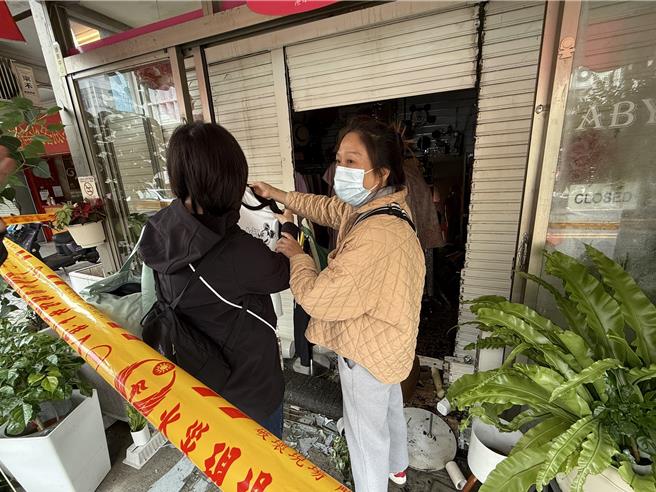 韩系进口服饰店老板娘仍设法抢救堪用的衣物。（宝智华摄）