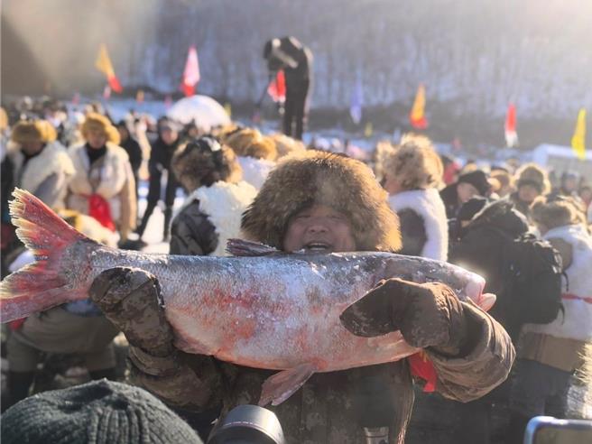 当地居民开心捧鱼拍照。（中视提供）
