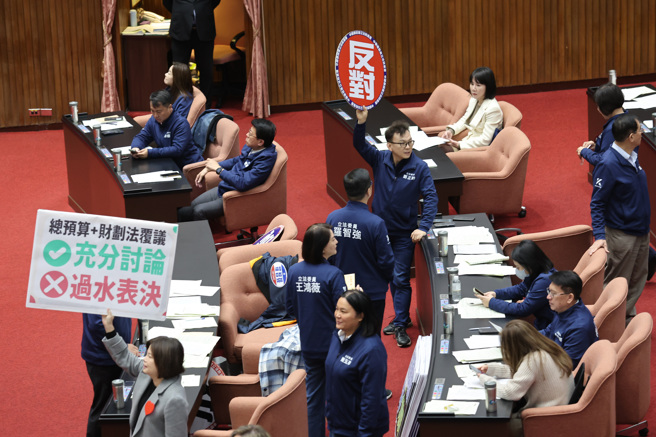 立法院7日院會表決行政院所提財劃法、中央政府總預算覆議案處理議程等相關事宜，民進黨立委在議場內舉著標語並高喊「充分討論、不要過水」表達立場，國民黨則高舉「反對」手牌。（姚志平攝）