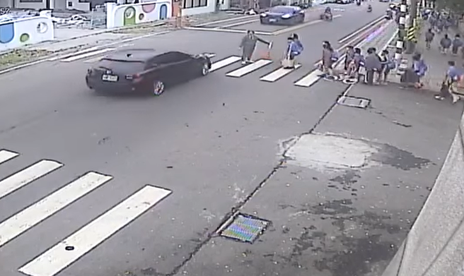 大群学生过马路，轿车未礼让闯红灯直衝。（翻摄爆废公社公开版）