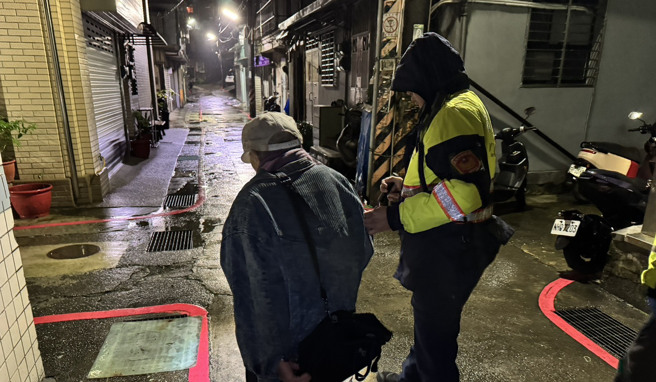 骤雨严寒老翁街上失足跌倒 ，暖警热心助载返家。（翻摄画面）
