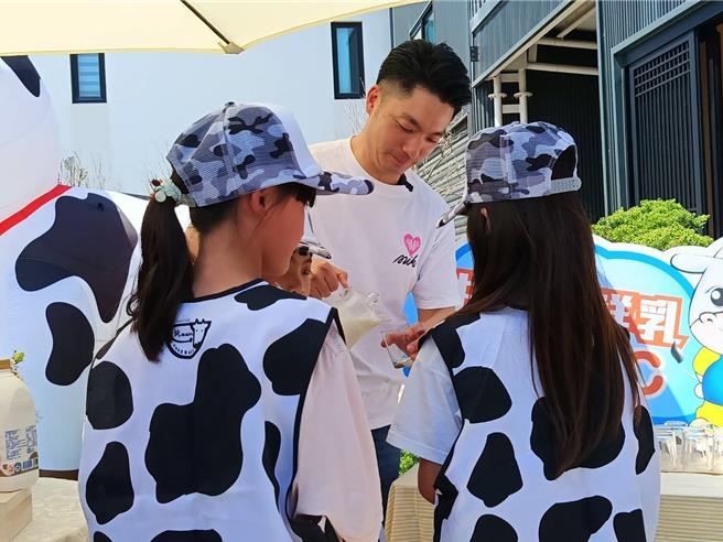 台北市长蒋万安（中）参访彰化酪农场，他与彰化学童分享在地优质鲜奶。（叶静美摄）