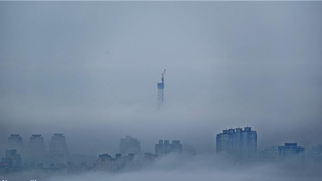 淡水笼罩在云海中，淡江大桥主桥塔非常明显。（张连荣提供）