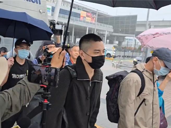 艺人王大陆涉逃兵役、教唆打人案交保后，13日入伍服役，出站时遇上大雨，有媒体替摄影机撑伞刚好替他挡雨，他眼带笑意看了一眼。（民眾提供／潘虹恩台中传真）