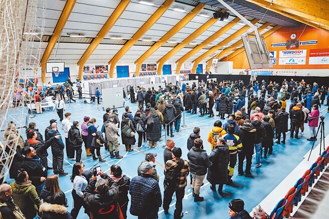 格陵兰主张「缓步自丹麦独立」的民主党（Demokraatit）11日击败现任左翼执政联盟，赢得议会选举。图为选民排队投票。（路透）