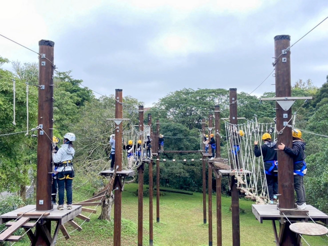 學員們挑戰高空繩索體驗，專注地行走在搖晃的繩索橋與木板道上，在高空環境下鍛鍊平衡感、專注力與團隊合作精神。(照片/聖約翰科大提供)

