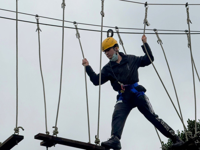 郭烜志同學進行高空繩索挑戰，他認為透過團隊合作與高空繩索課程，他學習到如何解決問題並提升溝通能力。(照片/聖約翰科大提供)