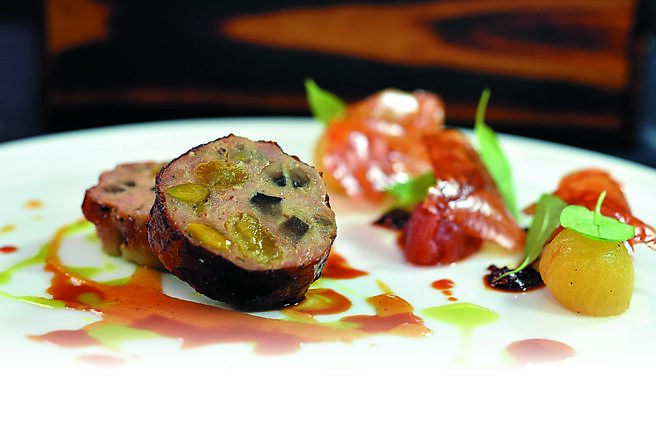 「鸡腿肉派」是以带皮去骨鸡腿肉盐浸后填入鸡腿排与带筋棒腿肉，搭配鸡肉慕斯、炒香野菇、金黄葡萄乾与开心果，经干邑、百里香、红椒粉腌制，风味层次丰富。图／姚舜