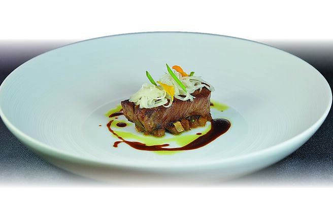 「炙烤牛舌」是以蔬菜及香料水低温炖煮牛舌，再炙烧增香， 口感外酥内韧，上层以腌渍茭白笋搭配。图／姚舜