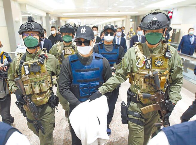 犯下台南学甲枪击案主谋洪政军（前排中）及枪手孔祥志（后排右）由刑事局除暴特勤队员押解至机场入境大厅前。（本报资料照片）