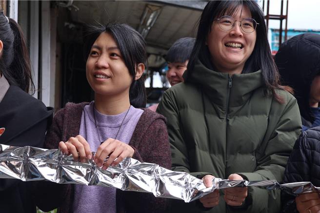文旅團隊今祭出三尾閃亮的白帶魚造型剪綵帶，實為三大串鋁箔包裝的蜜漬金桔果乾，當迎賓爆竹響起，所有與會大小嘉賓一同撕開銀色綵帶，迎來如雷的祝賀掌聲。（蘇澳鎮公所提供／吳佩蓉宜蘭傳真）