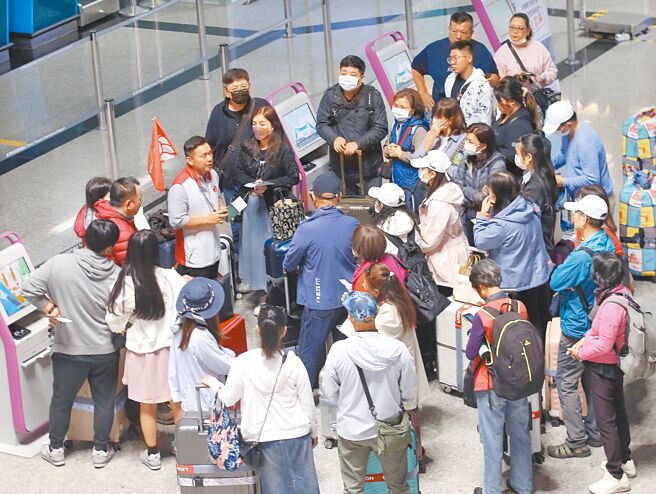 旅客出国游玩时购买仿冒品，6月起除商品没入外，还会被处最高1.5万元罚锾。示意图为在桃园机场内的旅行团，非新闻当事人。（本报资料照片）