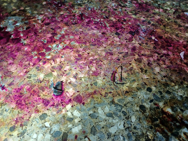 警方获报到场发现地上疑似自制爆裂物，染料内容物四散喷溅。（翻摄画面）