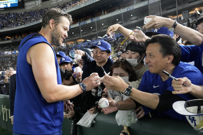 道奇明星左投柯萧（Clayton Kershaw）赛前亲切帮球迷签名。（图／美联社）