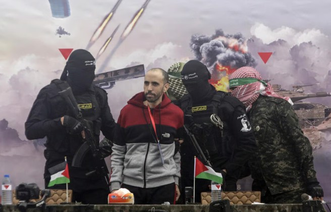 2月22日，以色列人质舒汉姆被哈玛斯释放，哈玛斯都要每个以色列人质归还时，都先举行个仪式。(图/美联社)