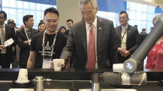 达明的机械手臂化身为全自动机器人咖啡师 「Ella」，在新加坡连锁咖啡厅Crown Coffee里泡咖啡，时任新加坡总理李显龙也喝了一杯。（图／翻摄自ella咖啡馆脸书）
