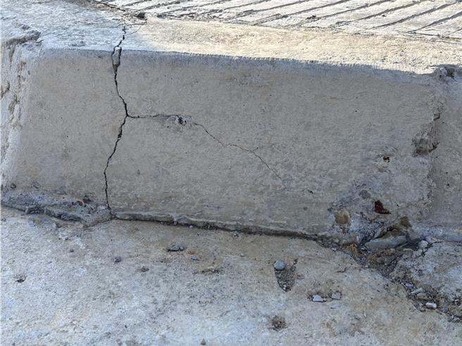 桃园航空城五权里安置街廓地内出现道路面凹凸不平、人行道铺面粗糙龟裂，人孔盖高低不一严重破损的状况。地方批，已开始点交工区却像废墟般，道路高低差严重，安置户进入点交恐有安全疑虑，且公设施工品质状况极差。（廖姮玥摄）