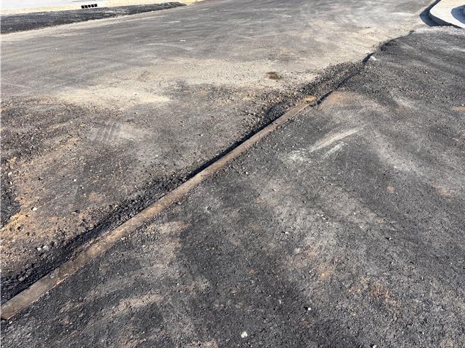 桃园航空城五权里安置街廓地内出现道路面凹凸不平、人行道铺面粗糙龟裂，人孔盖高低不一严重破损的状况。地方批，已开始点交工区却像废墟般，道路高低差严重，安置户进入点交恐有安全疑虑，且公设施工品质状况极差。（廖姮玥摄）