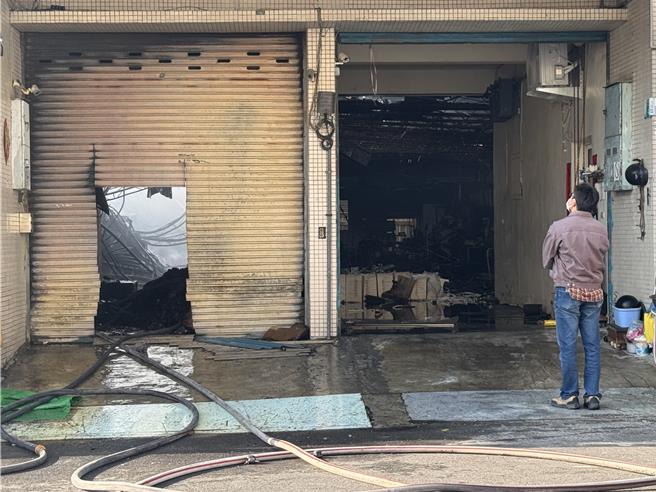 陈姓老妇人独自住在工厂楼上，儿子接获噩耗悲痛不已，站在工厂外凝望。（曹婷婷摄）