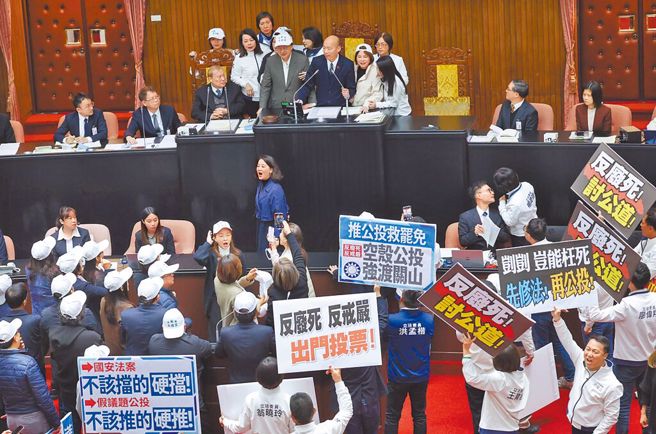 立法院21日原要处理公投案、行政院长卓荣泰施政总质询，民进党团总召柯建铭衝上主席台，蓝绿各自举标语喊口号吵成一团。（资料照，姚志平摄）