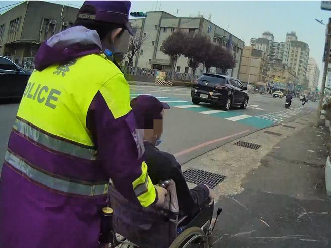 中坜警分局仁爱派出所员警日前巡逻，发现一名约50岁行动不便的男子正以单脚蹬地，倒退推动轮椅前进相当吃力，立即主动上前关心。（中坜警分局提供）