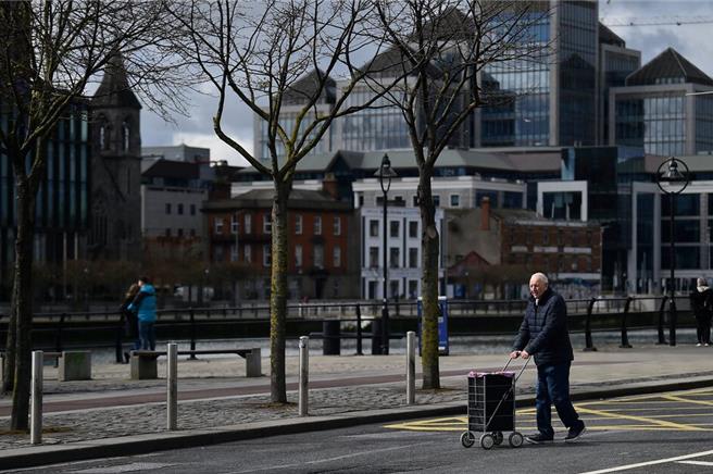 男性推着菜篮车穿越爱尔兰首都都柏林的中心商业区（图／路透社）