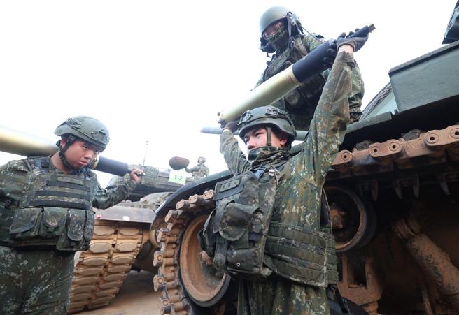 射击前，官兵协力将弹药搬运至炮塔内部，完成射击前准备。（记者黄迪明摄）