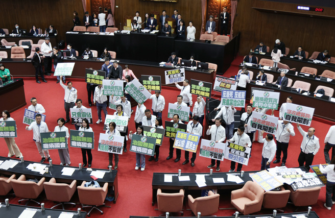 立法院25日院会，民进党立委霸占主席台杯葛议事，院长韩国瑜宣布休息，国民党立委拿出标语并高喊「民进党治国无能，瘫痪国会」。（姚志平摄）