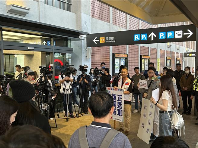 反對陸配的群眾到場舉牌諷刺亞亞遭驅離。（李文正攝）