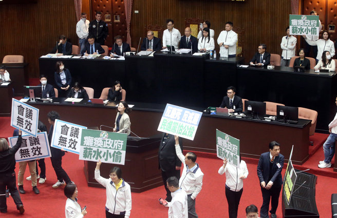 立法院25日院会，民进党立委霸占主席台杯葛议事，随后民进党立委在晚上6点依法定开会时间已到离开议场，但立法院长韩国瑜（后中）依《立法院议事规则》规定，至委员质询结束为止，在晚间7点20继续开会，虽然民进党团抗议会议无效，最后仍在国民党和民眾党人数优势下，表决闯关成功，径付二读后交付协商。（赵双杰摄）