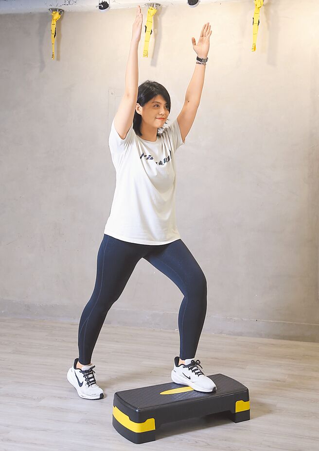 弓箭步點／雙腳站上踏板後，先右腳往後踩出弓箭步，同時雙手高舉，右腳回到踏板後，再換左腳後踩，反覆交錯操作。（趙雙傑攝）