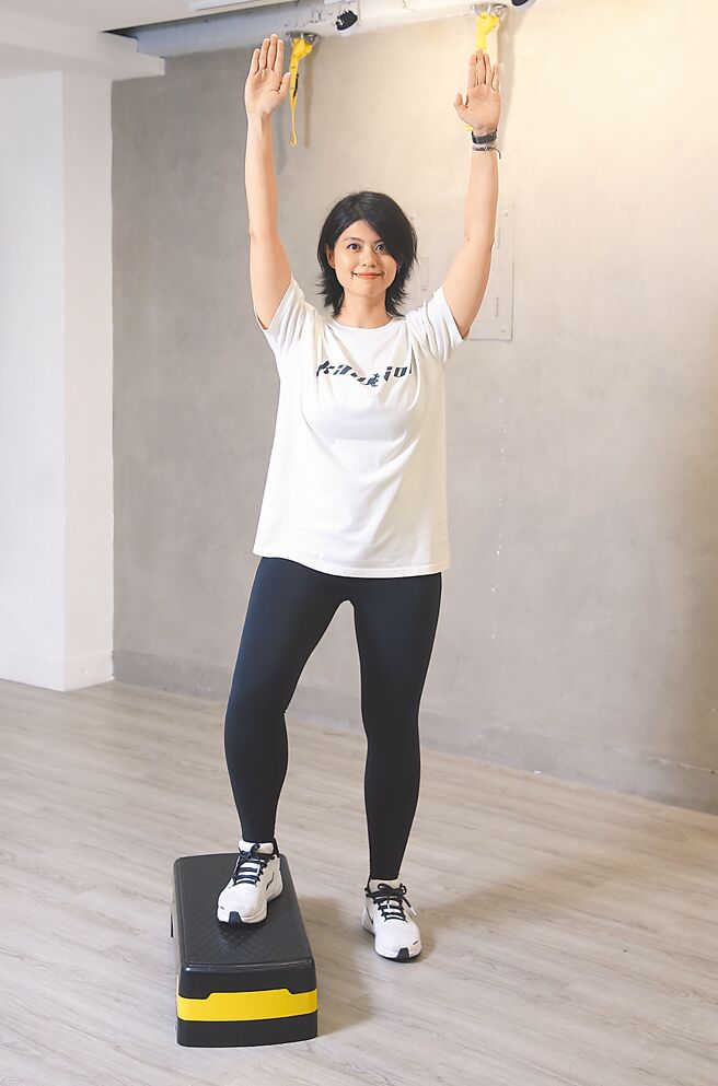 側面洗窗／面對踏板左轉90度，右腳踩上踏板時舉起雙手，左腳踩上時雙手放下，右腳從另一側下板時舉起雙手，左腳下板時雙手放下，再反向換左腳踩上踏板，於踏板兩側反覆操作。（趙雙傑攝）