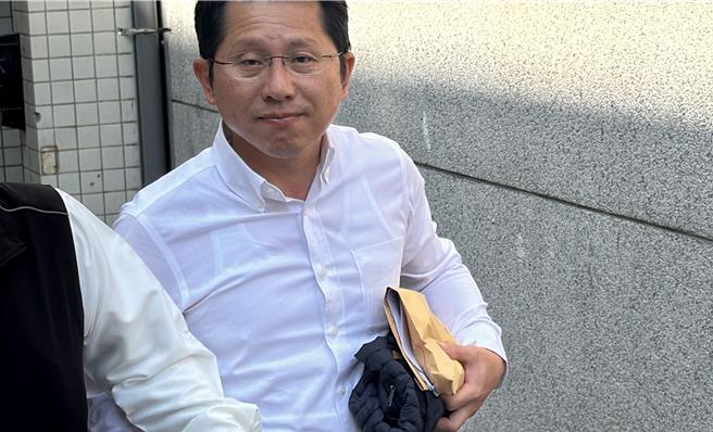 明良臻涉罢免案「查水表」被检方声押。法院裁定5０万元交保，他步出法院苦笑、面露疲惫。（王志伟摄）