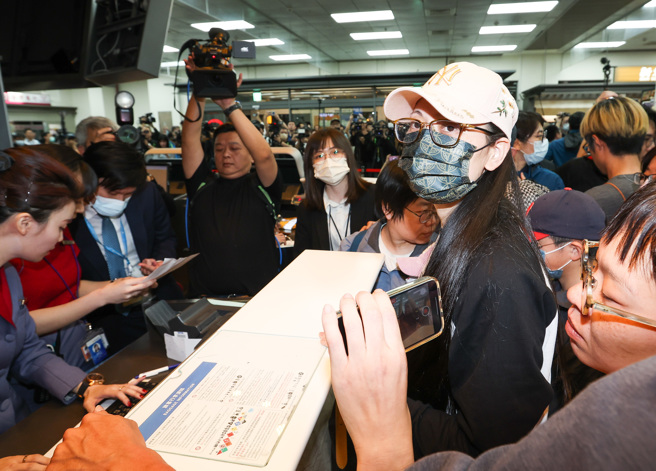 陸配網紅劉振亞「亞亞」（中戴白帽者）25日晚間，與孩子及老公現身松山機場在航空公司櫃台辦理手續，搭乘晚間20時45分廈門航空的班機前往福州。（資料照片/陳俊吉攝）