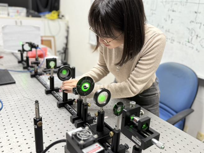 陈柏蓁在实验室里进行4f光学系统实验。（阳明交大光电系提供）