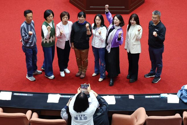 民进党团为阻挡25日院会议事录确认，28日占据议场主席台，让议事停摆一整天。散场后一阶达罢免门槛的民进党立委张宏陆（后排左起）、苏巧慧、何欣纯、伍丽华、陈莹、吴思瑶、吴沛忆、蔡其昌等8位高喊「恶霸 恶霸 我不怕」，国民党立委陈玉珍（中）急忙拿出手机拍照。（邓博仁摄）