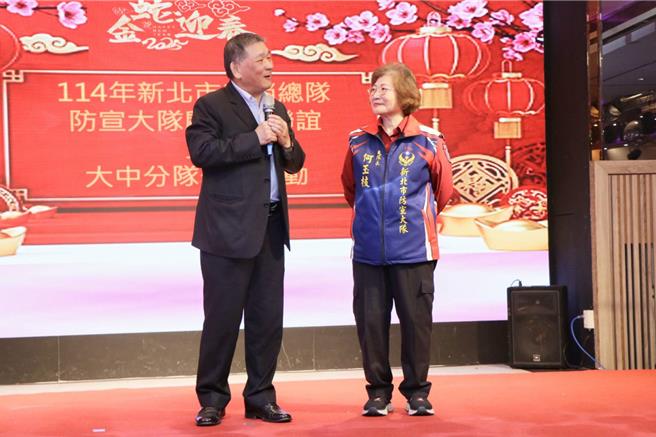 消防署副署长简万瑶颁赠1万元慰劳金予义消防宣大队大队长何玉枝。（图／新北市消防局）