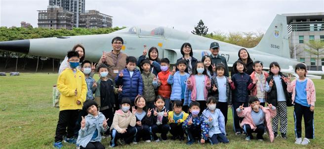 大直国小师生们与政战局文宣心战处处长楼少将，在博爱营区军史公园内与F-5E战机合影留念。（记者王子昌摄）