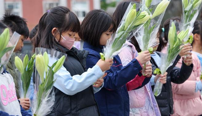 大直国小学童们于「0102纪念专区」前进行献花，感谢国军英勇将士用生命守护国家。（记者王子昌摄）