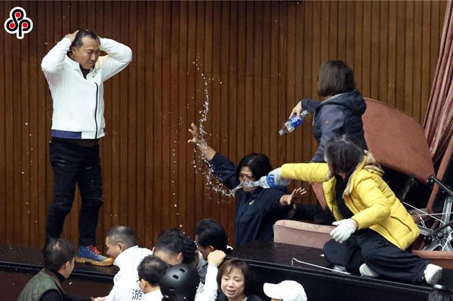 立法院会去年12月20日处理选罢法、宪法诉讼法及财划法修正草案等案，蓝绿发生衝突，绿委赖惠员、陈培瑜（右）频朝蓝委泼水。（本报资料照，邓博仁摄）