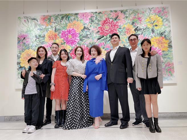 韓湘琴一襲寶藍套裝（中）開畫展，全家總動員。老公唐威（右2）、唐志中（左3）、唐可珊（左5）到場。（韓湘琴提供）